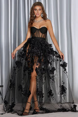 Woman in a black strapless formal gown with a sheer, floral-embellished skirt