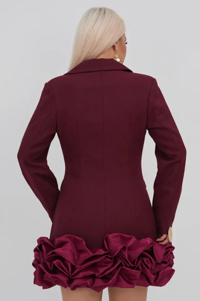 Back view of a woman in a maroon double-breasted blazer dress with a ruffled hem