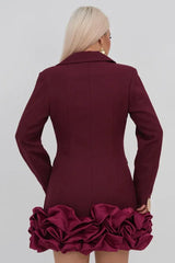 Back view of a woman in a maroon double-breasted blazer dress with a ruffled hem