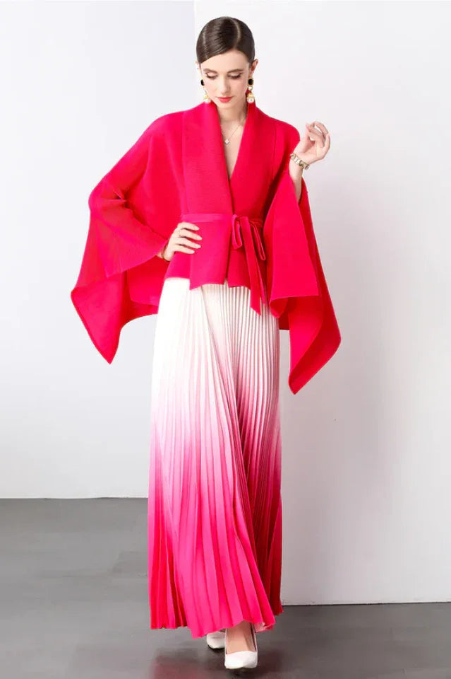 Model wearing a bright pink wrap top and white to bright pink ombre pleated maxi skirt.