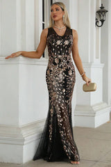 Woman posing in a black and gold sequined sleeveless mermaid dress.