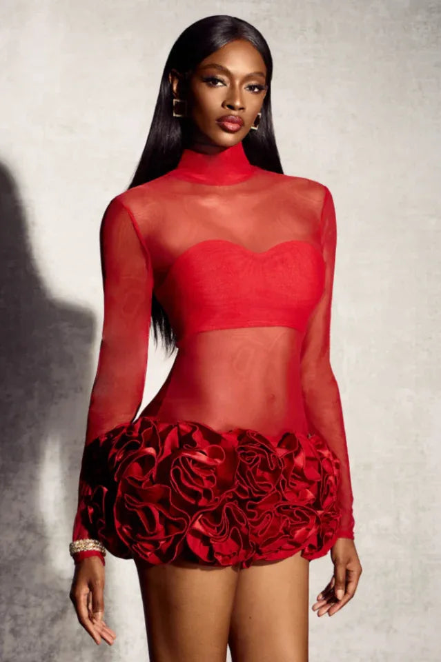 Model wearing a red sheer mini dress with ruffled hem