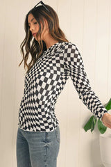 Side view of a woman wearing a black and white checkerboard long-sleeved mesh top and blue jeans.