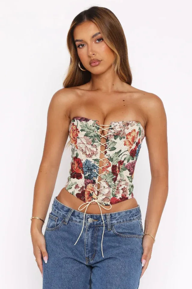 Woman wearing a strapless floral tapestry corset with lace-up front and blue jeans