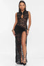 Woman wearing a black lace maxi dress with a high neckline and a thigh-high slit, front view.