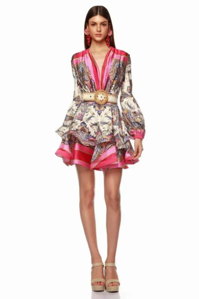 full body shot of a model in a paisley print mini dress with a v-neck and tiered skirt