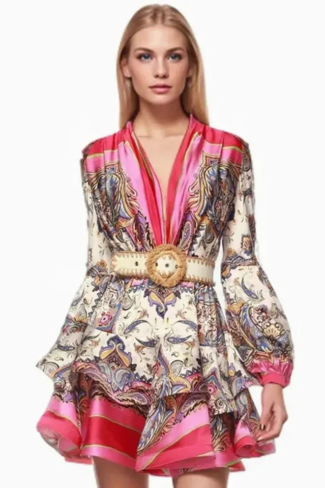 model wearing a pink and white paisley print mini dress with long bell sleeves and a belted waist