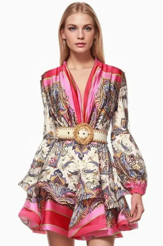 model wearing a pink and white paisley print mini dress with long bell sleeves and a belted waist