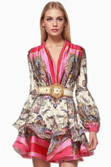 model wearing a pink and white paisley print mini dress with long bell sleeves and a belted waist