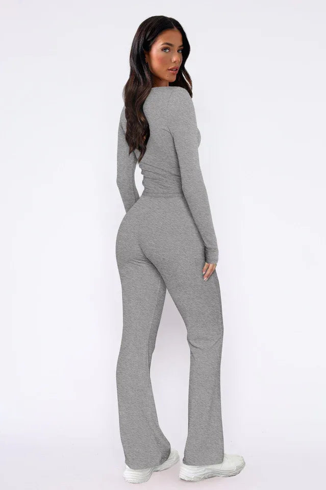 Woman wearing a grey ribbed knit long-sleeve top with button detail and matching flared pants, back view.