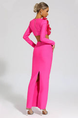 Rear view of a woman in a bright pink two-piece evening gown with a square neckline, long sleeves, and a floor-length mermaid skirt with a high slit. The back of the top features a zipper closure.
