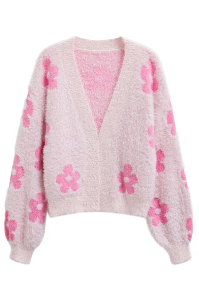 A pink fluffy knit cropped cardigan with a floral print, laid flat.