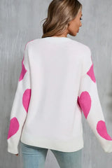 Back view of a woman wearing a white sweater with a pink heart print.