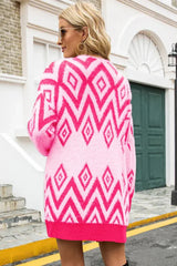 Back view of a woman wearing a pink and white geometric pattern fluffy knit longline cardigan