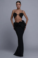 Woman wearing a black two-piece evening gown with rose embellishments on the bust and waist
