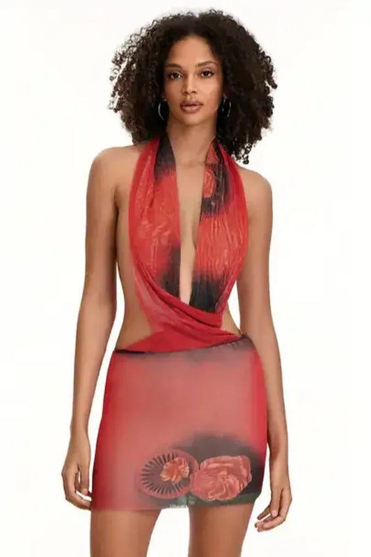 Woman wearing a red and black floral print sheer mesh halter mini dress with cut-out details