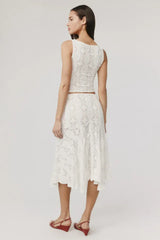 Back view of a woman wearing a white crochet knit cropped tank top and a white crochet knit asymmetrical hem midi skirt.