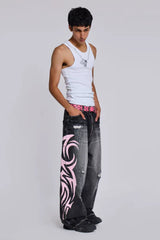 Side view of model wearing wide leg jeans with tribal print and a white tank top