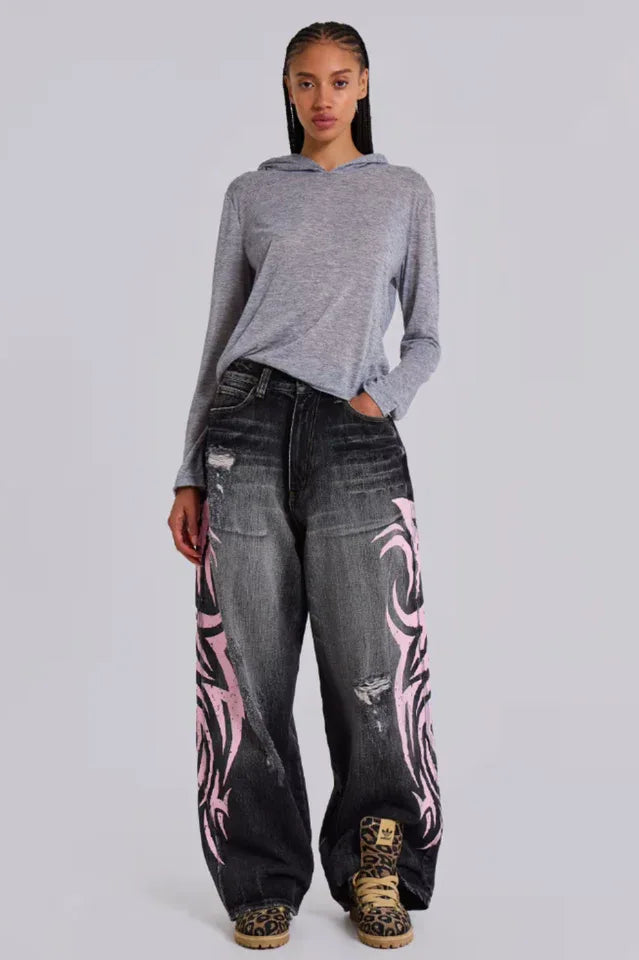 Model wearing wide leg jeans with tribal print and a grey hoodie