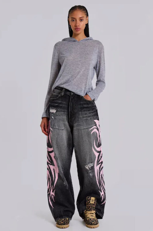 Model wearing wide leg jeans with tribal print and a grey hoodie