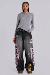 Model wearing wide leg jeans with tribal print and a grey hoodie