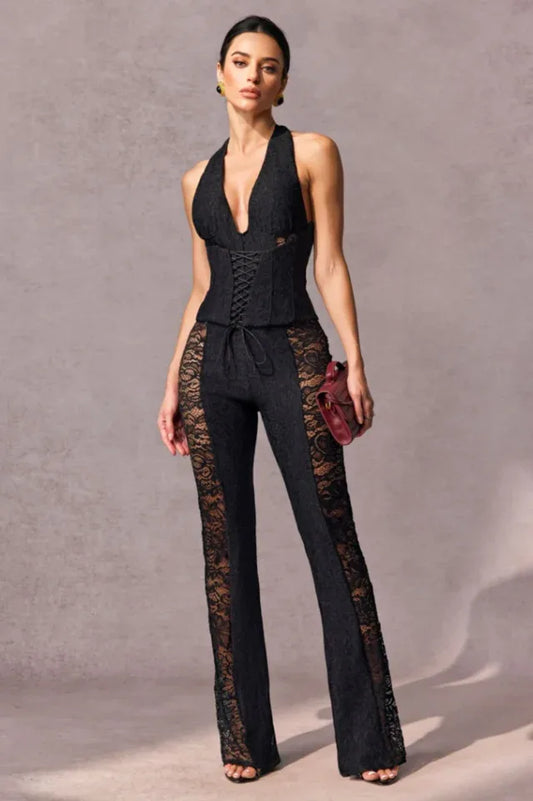 Woman wearing a black lace halter top and flared pants with lace insets