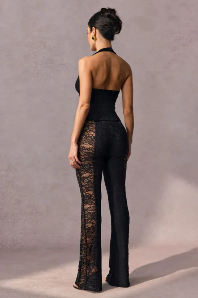 Back view of a woman in a black lace halter top and flared pants