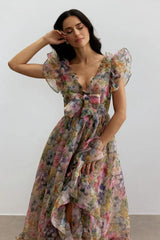 Close-up of a woman wearing a floral print chiffon gown, highlighting the neckline and sleeve details.