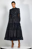 Woman wearing a long black tiered lace dress with a high neckline and long sleeves