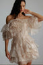 Model wearing a light pink, off-the-shoulder, ruffled mini dress with a floral accent on the bodice.