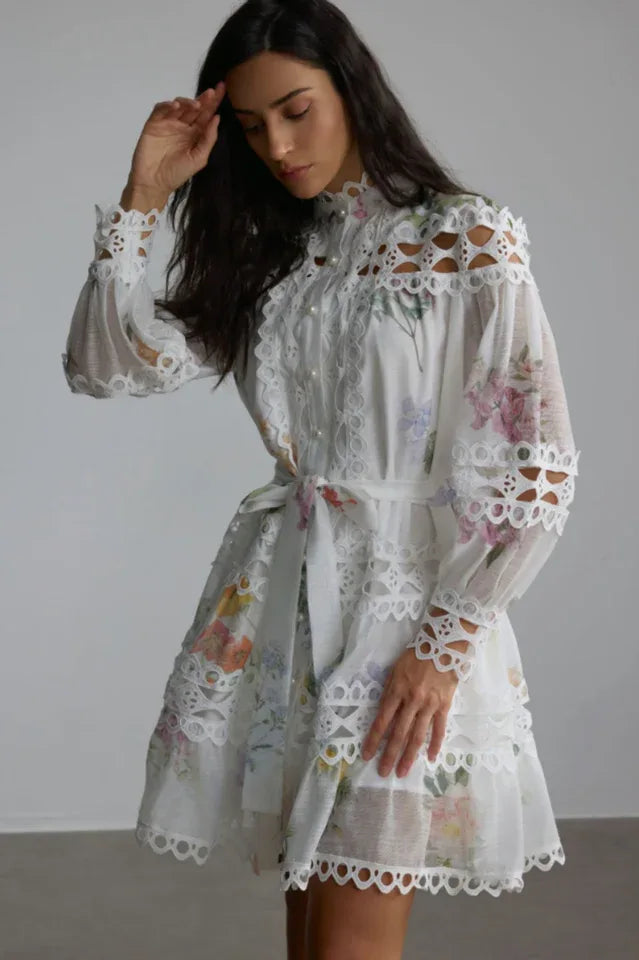 Close-up of a woman's face and upper body in a white floral lace dress