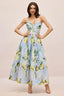 Woman wearing a light blue midi dress with a lemon print, spaghetti straps, a sweetheart neckline, and a full skirt.