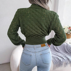 Back view of a woman wearing a green mock neck cropped knit sweater with light wash jeans.