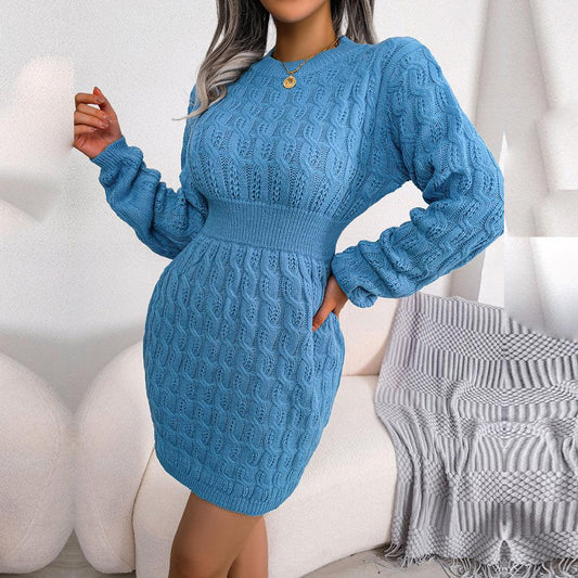 Woman wearing a blue knit mini dress with long sleeves and a cinched waist, standing in a living room setting.