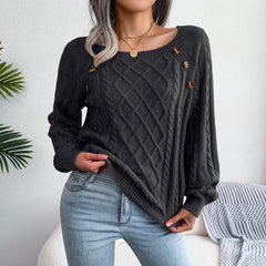 Woman wearing a charcoal grey cable knit sweater with scoop neck and button details, paired with light wash jeans.
