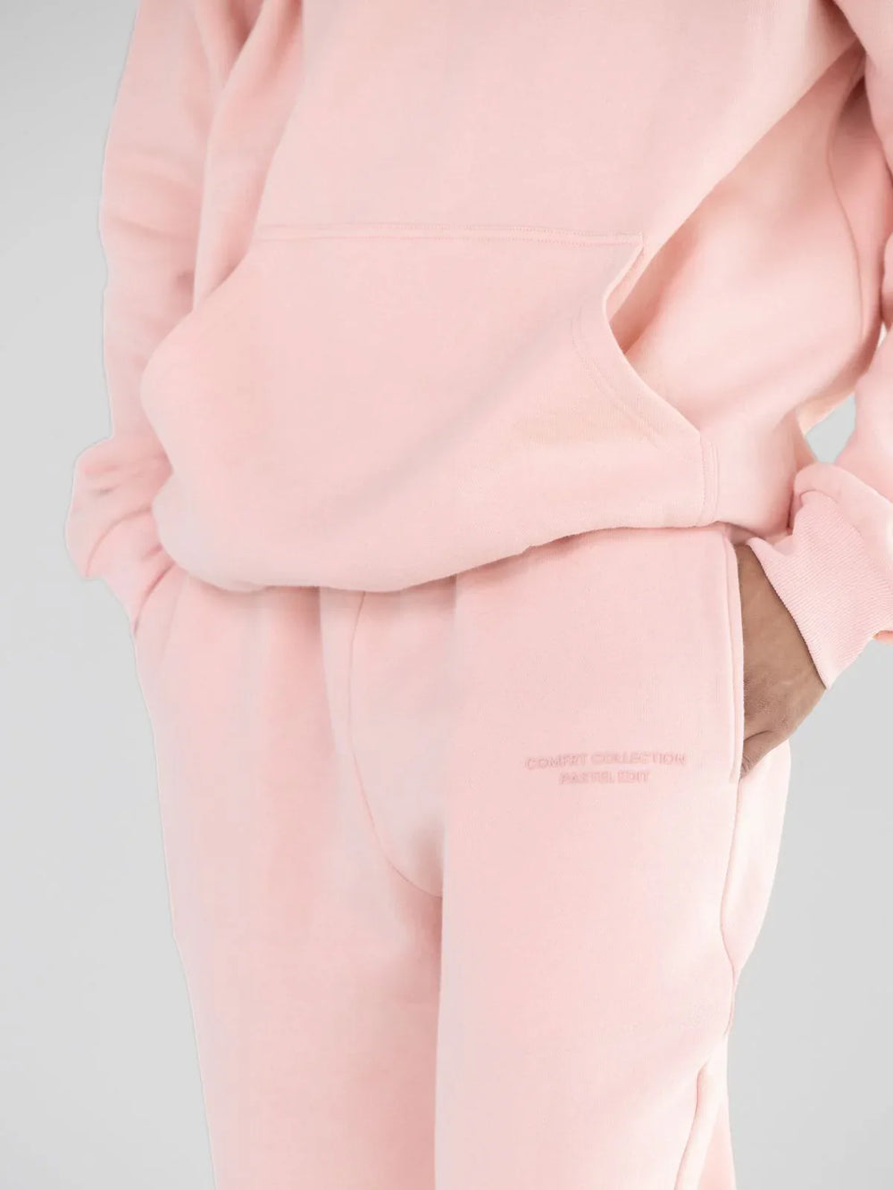 Close-up of the embroidered detail on light pink sweatpants