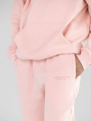 Close-up of the embroidered detail on light pink sweatpants