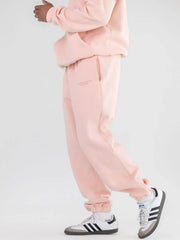 Model wearing light pink sweatpants and white sneakers