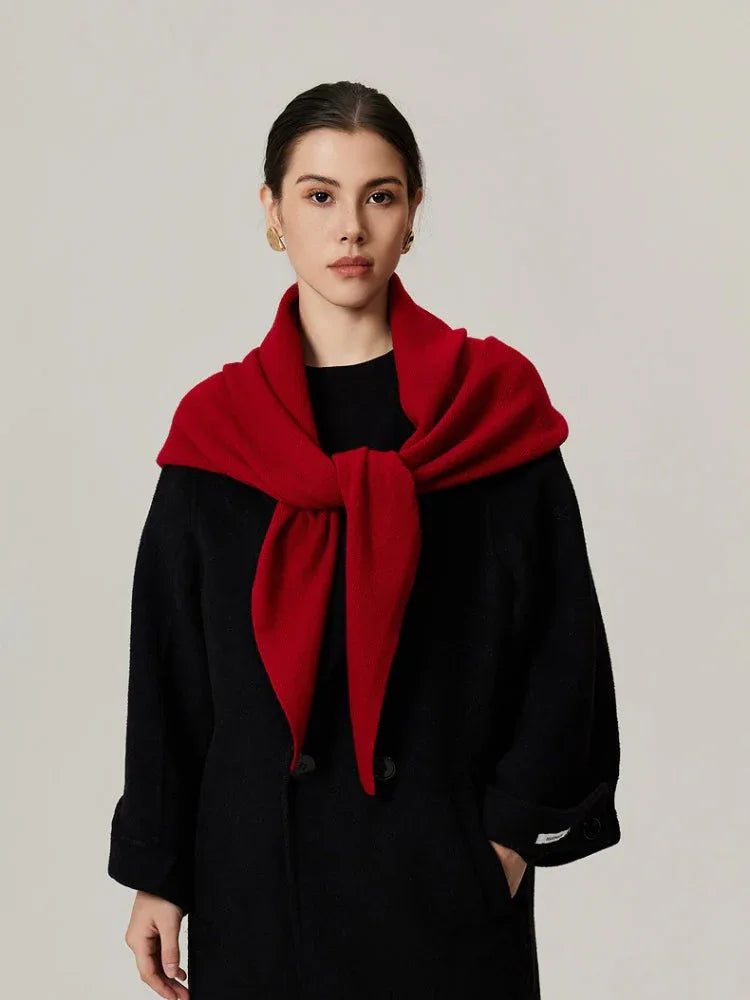 Woman wearing a red scarf tied at the front over a black coat
