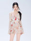Woman wearing a floral print mini dress with a sheer cardigan