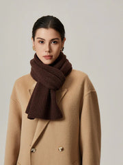 Close-up of a woman wearing a brown ribbed knit scarf.