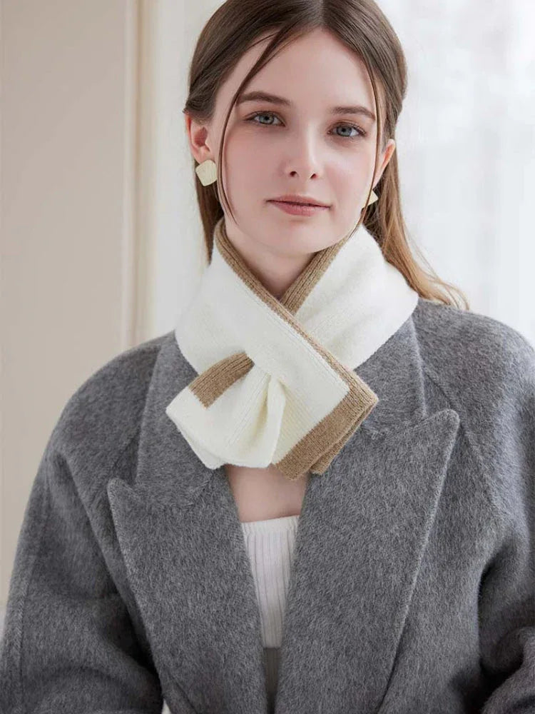 Woman wearing a white top and a tan and white striped scarf