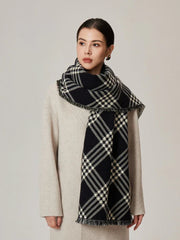 Woman wearing a cream coat and a black and white tartan scarf