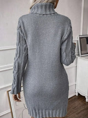 Back view of a woman wearing a grey cable knit turtleneck mini dress.