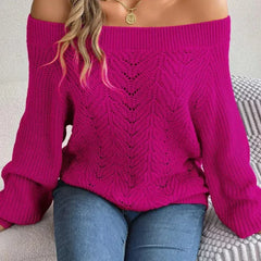 Woman sitting on a couch wearing a fuchsia off-the-shoulder knit sweater.