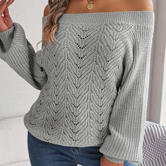 Woman wearing a light gray off-the-shoulder knit sweater with an open-knit pattern and long sleeves.