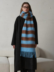 Full-body view of a woman in a black coat and a blue and brown striped scarf