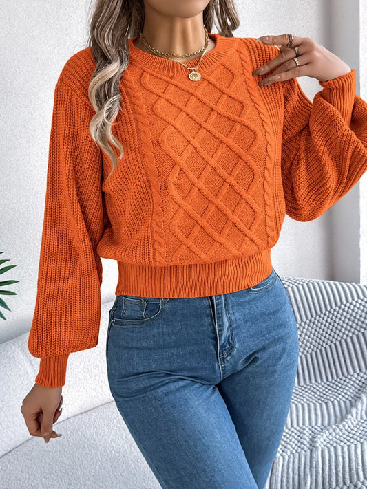 Woman wearing an orange cable knit sweater with blue jeans