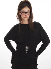 Front view of a woman wearing a black long-sleeve mini dress, star-patterned tights, and glasses.