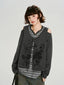 Model wearing a grey long-sleeve top with cold shoulder cutouts and a graphic print, layered over a striped t-shirt.